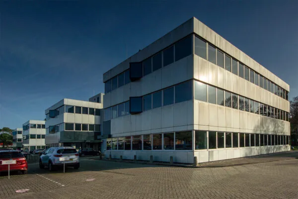 Modern kantoorpand aan de Huis ter Heideweg met meerdere verdiepingen en parkeerplaatsen op de voorgrond.
